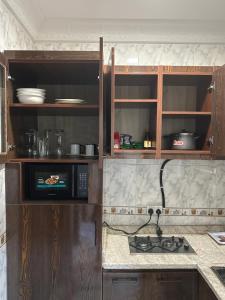 a kitchen with wooden cabinets and a stove top oven at Lesley and Lindsey luxurious short let in Gwarinpa