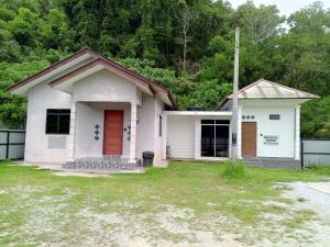 a small white house with a red door at Homestay Idaman B B with 2 room aircond 2 Quen Bed and Not Sharing Room -Privacy in Kuala Terengganu