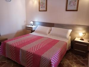 a bedroom with a bed with a red and white blanket at Da Giusy le petit bijou in Castelbuono