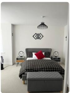 a bedroom with a bed with a red pillow on it at Bedroom in West Sussex with locks,Private Bathroom & Free Parking in Pulborough