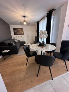 a living room with a table and chairs and a couch at Disneyland Dream 4 - Charmant Appartement 7 pax in Chessy