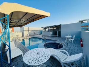Un patio con mesa y sillas y una piscina. en Le Paradise Palace Hotel Deira Dubai Al Rigga, en Dubái