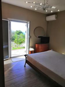una camera da letto con un letto e una grande finestra di Oasis Escape Villa Loutraki a Loutraki