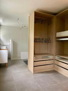 a kitchen with wooden cabinets and a tiled floor at Maison de famille 5 ch idéale pour des réunions de familles in Sainte-Luce-sur-Loire