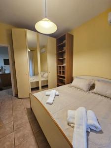 a bedroom with a large bed with towels on it at KT Apartment in Drama +10 photos