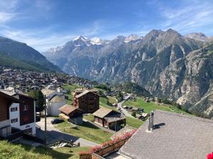 a village in the mountains with mountains in the background at Haus Dorfblick in Grächen