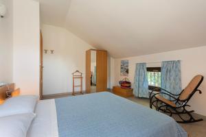 a bedroom with a bed and a chair in it at La Casa di Amalia in Gavi