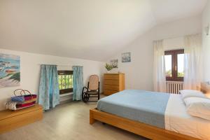 a bedroom with a bed and a chair and a window at La Casa di Amalia in Gavi