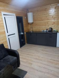 a living room with a couch and a kitchen at Sevanta Lake Cottages in Sevan