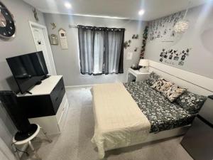 a bedroom with a bed and a desk and a television at Private, Secure, Immaculate & Cozy Room in Brampton