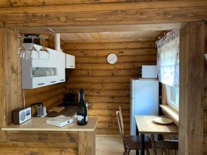 a small kitchen with a table and a refrigerator at Mājīga guļbūve pie jūras! in Bigauņciems