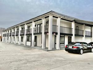 a building with a car parked in front of it at ECONOMY INN AND SUITES in Tulsa