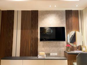 ein Wohnzimmer mit einem Fernseher an der Wand in der Unterkunft Luxurious La Luna at Gold Coast Sea View in Jakarta