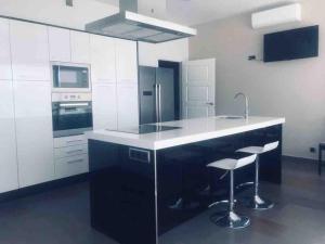 TotanésにあるCasa Rural AlMaのキッチン(白黒のカウンター、スツール付)