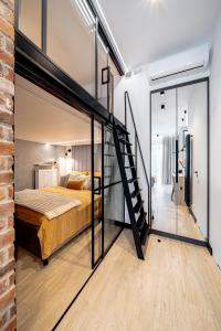 a bedroom with a bed and a glass wall at BalticSky Loft Premium, Apartament K o ł o b r z e g in Kołobrzeg
