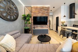 a living room with a couch and a large clock on the wall at BalticSky Loft Premium, Apartament Kołobrzeg, Basen, Jacuzzi, Sauna in Kołobrzeg