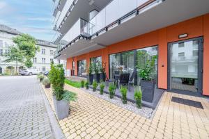 an orange building with potted plants in front of it at BalticSky Loft Premium, Apartament Kołobrzeg, Basen, Jacuzzi, Sauna in Kołobrzeg