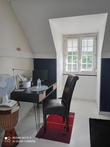 a desk and chair in a room with a window at Nuitée ZEN in Montigny-le-Chartif