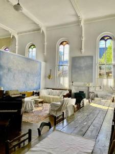 a large room with a piano and a living room at Church Des Artistes in Kingston