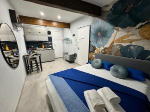 a bedroom with a blue bed and a kitchen at La Casa di Jennifer nel centro in Parma