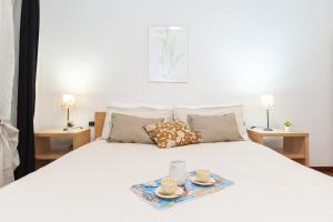 a bed with two cups and saucers on it at -2 Passi dal Mare- Centro Storico in Varazze