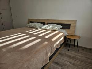 a bedroom with a bed with a wooden head board at Draugyste Apartment in Šiauliai