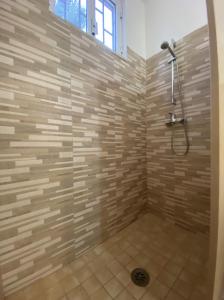 a bathroom with a shower with a stone wall at Camping Villaggio Pineta Al Mare in Specchiolla 