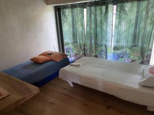 two beds sitting in a room with a window at Chalet San Martino in Cantalupa