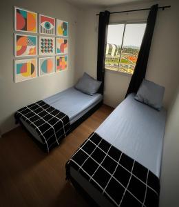 twee bedden in een kleine kamer met een raam bij Prático Viena - Free Parking - 24 hour doorman in Parque Industrial