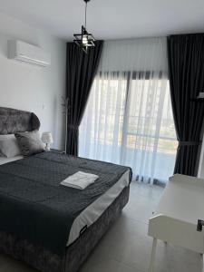a bedroom with a black bed and large windows at Caesar Resort Didious in Iskele +29 photos