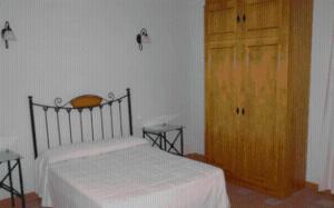 een slaapkamer met een bed en een houten deur bij Alojamiento rural la Bellosina in Cabezabellosa