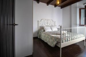 a white bedroom with a bed with a crib at Apartamento El Mirador del Parque in Setenil
