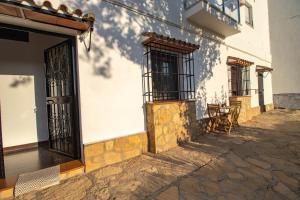 a building with doors and windows and a patio at Apartamento El Mirador del Parque in Setenil