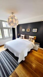 a bedroom with a large white bed with a chandelier at Velvetamsterdam in Amsterdam
