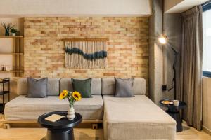 a living room with a couch and a brick wall at Caliza Roma Residences by Tasman in Mexico City +182 photos