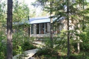 une maison au milieu d'une forêt plantée d'arbres dans l'établissement Haarusmaa Holiday Apartments Kauhava, à Härmä