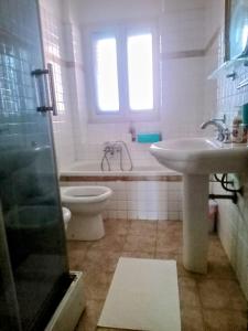 a bathroom with a sink and a toilet and a tub at Adelia House in Catania