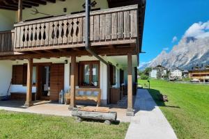 a house with a balcony and a bench in the yard at 3BDRM Luxury Magic Flat near Cortina with Garage in Villanova