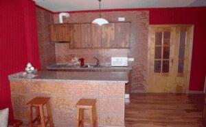 a kitchen with a counter and stools in a room at Alojamiento rural la Bellosina in Cabezabellosa