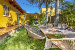 una mesa y sillas en el patio trasero de una casa en Casa Vista Teide con Jardín, Barbacoa y Fuente Zen, en Icod de los Vinos
