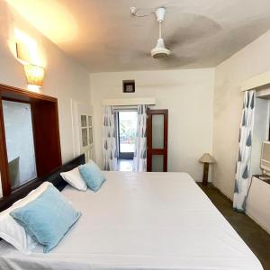 a bedroom with a large white bed with blue pillows at The Lata's- A Pet-Friendly Villa in Jaipur