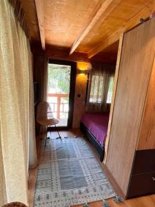 ein kleines Zimmer mit einem Bett und einem Fenster in der Unterkunft Sani Tree House in Sani Beach