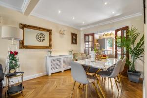Un comedor con mesa y sillas en Casa Marina- 4 bedroom house with garden and balcony, en Golders Green