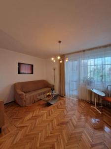 un salon avec un canapé et un parquet dans l'établissement Happy Yonder - Piața Romană - lângă metrou, à Bucarest