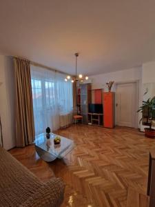 un salon avec un parquet et une table dans l'établissement Happy Yonder - Piața Romană - lângă metrou, à Bucarest 8 autres photos