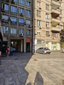 une voiture garée devant un grand bâtiment dans l'établissement Happy Yonder - Piața Romană - lângă metrou, à Bucarest