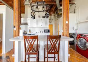 デトロイトにあるDetroit Riverview Loftのキッチン(白いカウンター、椅子2脚付)