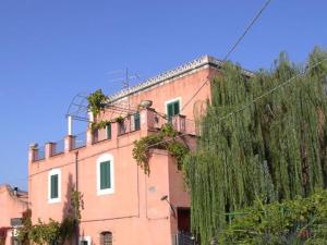 a pink building with ivy on the side of it at Holiday House Taormina in Trappitello +13 photos