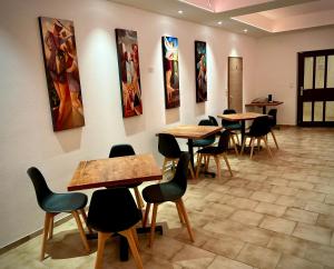 a waiting room with tables and chairs and paintings on the walls at BenDorma in Hannover
