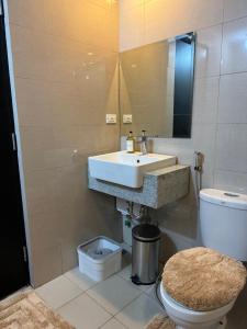 a bathroom with a sink and a toilet at Stylish 1BR Near Airport Facing the Bay - 7b in Manila
